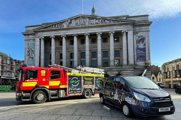 Photo of a fire engine and a community fire vehicle wrapped in the 'Safe Space Pledge' in front of the Nottingham Council House, Old Market Square