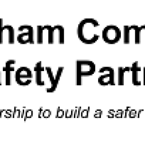 Logo: 'Nottingham Community Safety Partnership' written over two lines in black, with 5 vertical bars on the second line in green, black, blue, purple and red. Underneath written in Italics is 'working in partnership to build a safer and stronger city.'