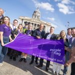 Representatives holding up the purple flag