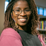 Picture of a Black woman smiling in a library