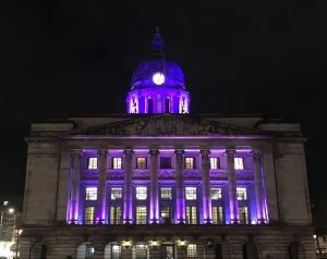 Photo of Nottingham Council House illuminated purple against the night sky