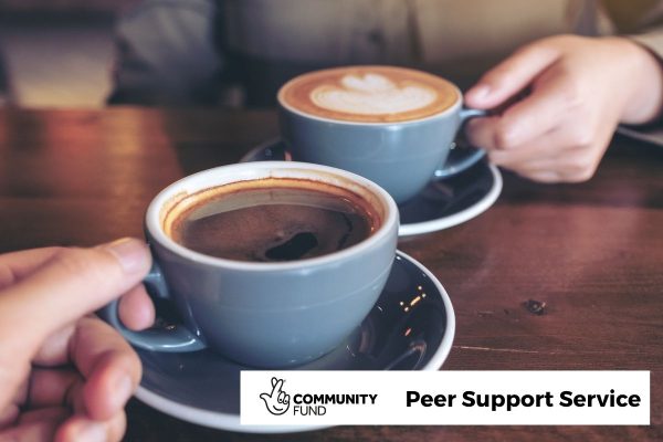 2 Two 'barista style' coffee cups, each with their handle being held. We are positioned as if we are one of those people. In the bottom right is the National Lottery Community Fund logo and the words 'Peer Support Service'