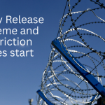 A photo of barbed wire, edging a prison, against the blue sky. Against the sky in white text is 'Early Release Scheme and Restriction Zones start'